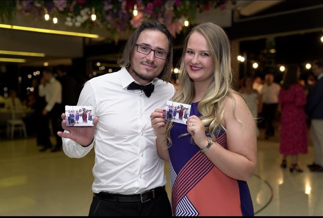 A couple holding their freshly-printed photo magnets