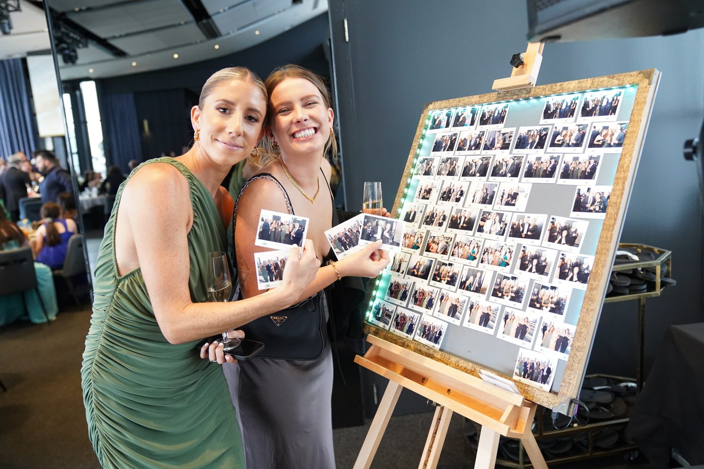 Two guests holding their photo magnets at a party